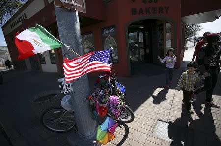 Passers-by look at a bike adorned with trinkets and Mexican and the U.S. flags in Pasco, Washington March 21, 2015. REUTERS/Ross Courtney