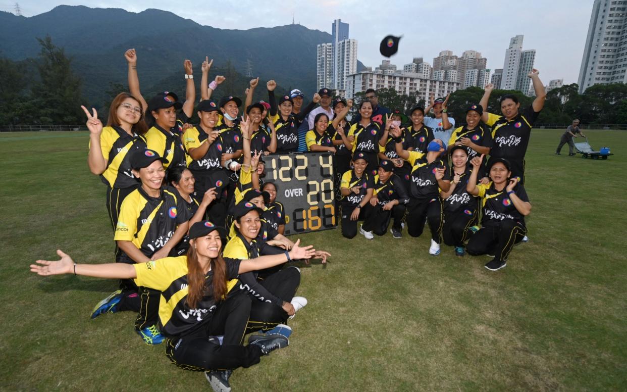 The SCC Divas cricket team, made up of domestic helpers from the Philippines, celebrating their win against the Hong Kong Cricket Club Cavaliers in Hong Kong - PETER PARKS /AFP