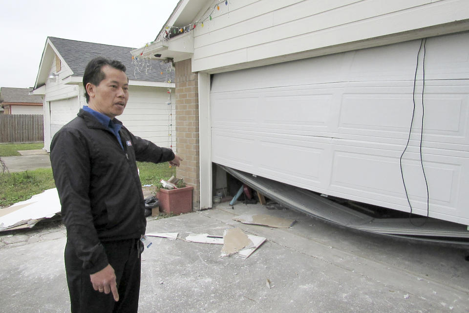 In this Thursday, Jan. 30, 2020 photo, Houston resident Quan Nguyen talks about the damage, including a twisted garage door, his home sustained after the Jan. 24, 2020, explosion at a nearby industrial business. Last month's explosion at a Houston metal fabricating and manufacturing company that killed two workers and damaged hundreds of structures has renewed debate over the city's lack of zoning. (AP Photo/ Juan Lozano)