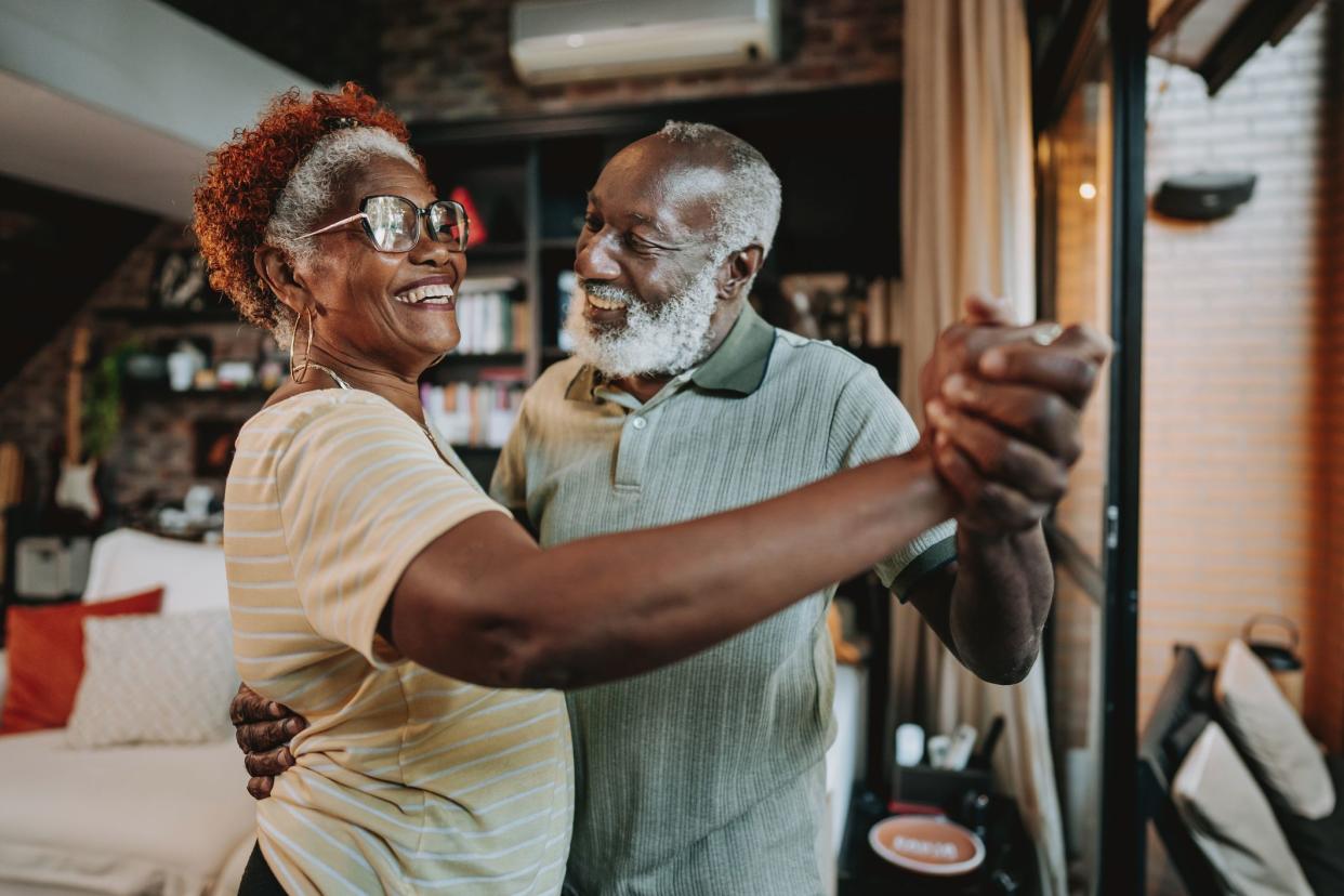 Senior couple dancing at home