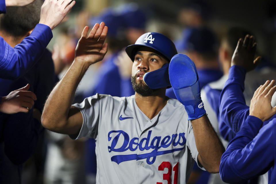 Los Angeles Dodgers' Amed Rosario celebrates in the dugout after scoring off a sacrifice fly by Kolten Wong against the Seattle Mariners during the 10th inning of a baseball game Saturday, Sept. 16, 2023, in Seattle. (AP Photo/Maddy Grassy)