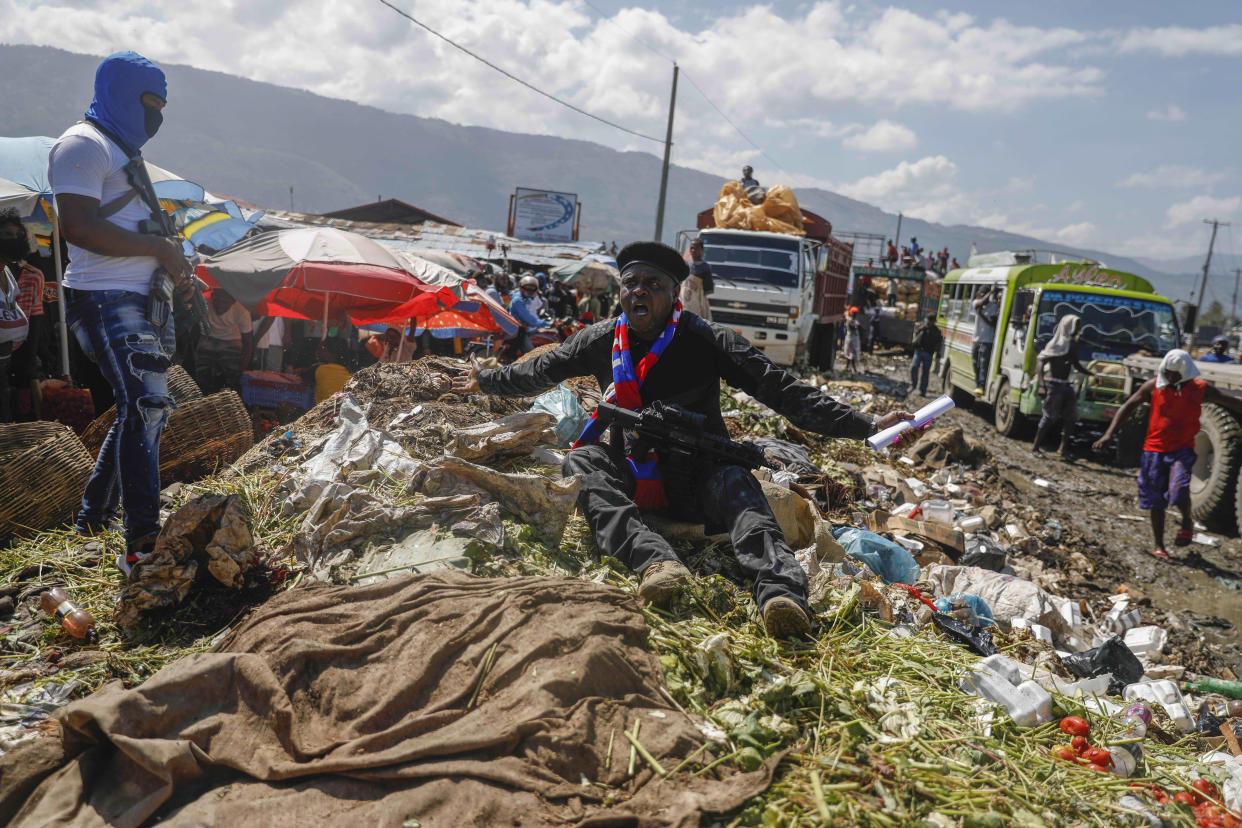 FILE - Barbecue, the leader of the "G9 and Family" gang, sits on garbage to call attention to the conditions people live in as he leads a protest march against kidnappings through La Saline neighborhood in Port-au-Prince, Haiti, Oct. 22, 2021. The U.S. government is urging U.S. citizens to leave Haiti given the country’s deepening insecurity and a severe lack of fuel that has affected hospitals, schools and banks. Gas stations remained closed on Thursday, Nov. 11, 2021, a day after the State Department issued its warning. (AP Photo/Odelyn Joseph, File)