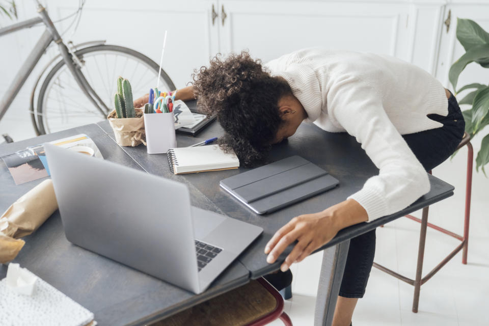Tired woman with face planted on a desk.