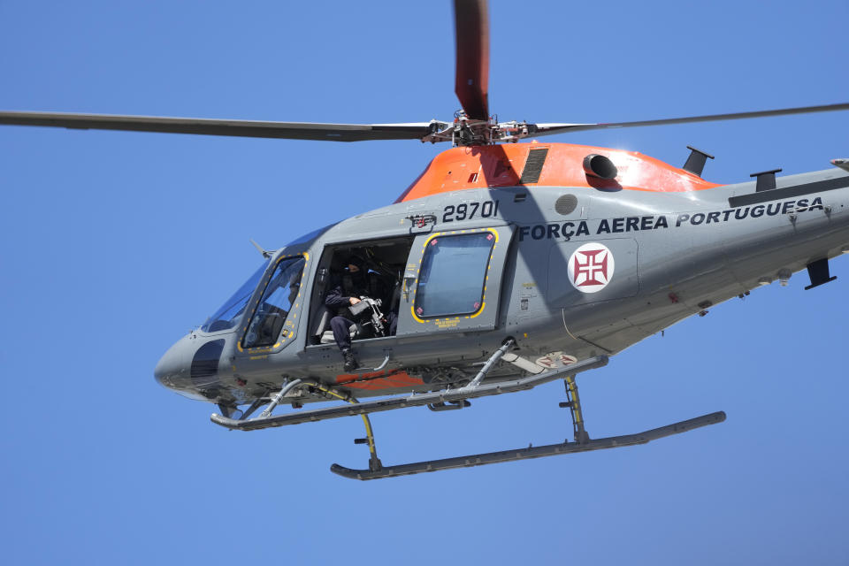 A Portuguese airforce helicopter hovers above the motorcade with Ukrainian President Volodymyr Zelenskyy at the military airport in Lisbon, Tuesday, May 28, 2024. (AP Photo/Armando Franca)