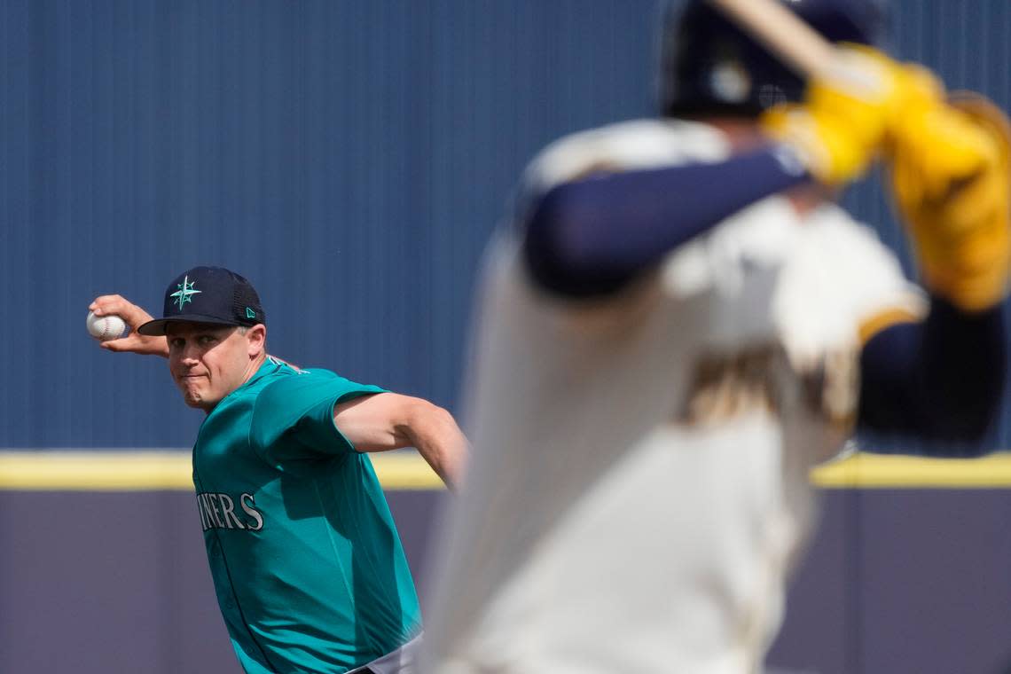 Seattle Mariners relief pitcher Paul Sewald, left, throws against Milwaukee Brewers’ Luis Urias during the fourth inning of a spring training baseball game Sunday, March 5, 2023, in Phoenix.