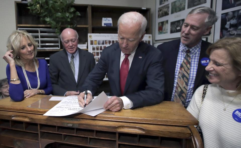 Democratic presidential candidate former Vice President Joe Biden files to have his name listed on the New Hampshire primary ballot, Friday, Nov. 8, 2019, in Concord, N.H. At left is his wife Jill Biden, and New Hampshire Secretary of State Bill Gardner. (AP Photo/Charles Krupa)