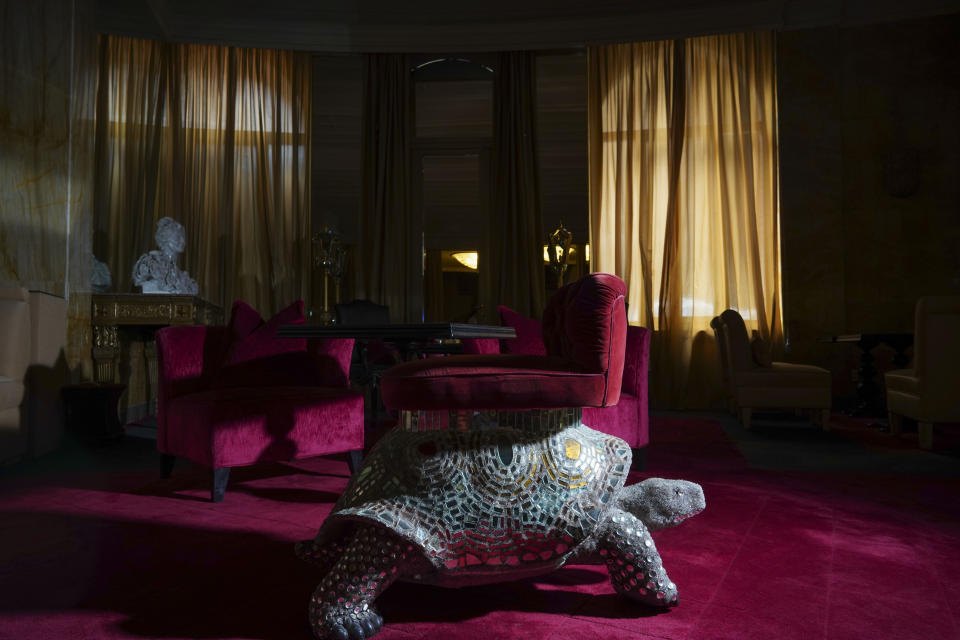 In this Wednesday, May 13, 2020 photo a turtle-shaped lounge chair is enveloped in the dark as curtains are closed at the Hotel Hassler, in Rome. The hotel, currently closed to the public after lockdown measures to prevent the spread of COVID-19 brought national and International leisure travel to a halt. Normally during Springtime, it would have an 83%-100% occupancy. (AP Photo/Andrew Medichini)