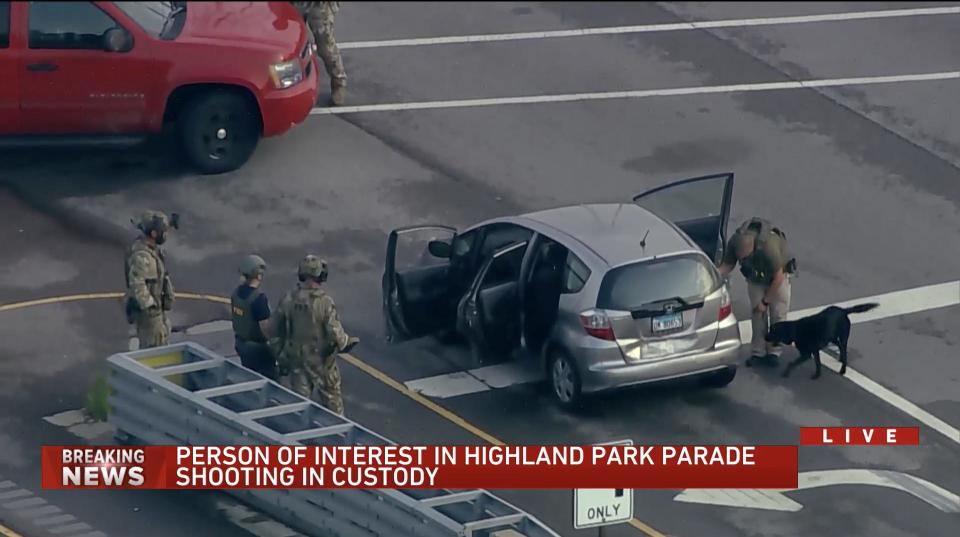 Screenshot from Chicago's WGN-TV showing person of interest in Highland Park, Illinois, shooting, being taken into custody.
