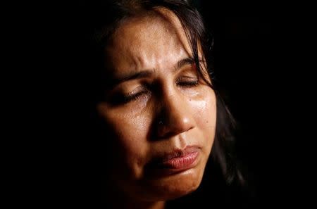 A woman cries as she attends a candle light vigil for the victims of attack on the Holey Artisan Bakery and the O'Kitchen Restaurant, in Dhaka, Bangladesh, July 3, 2016. REUTERS/Adnan Abidi