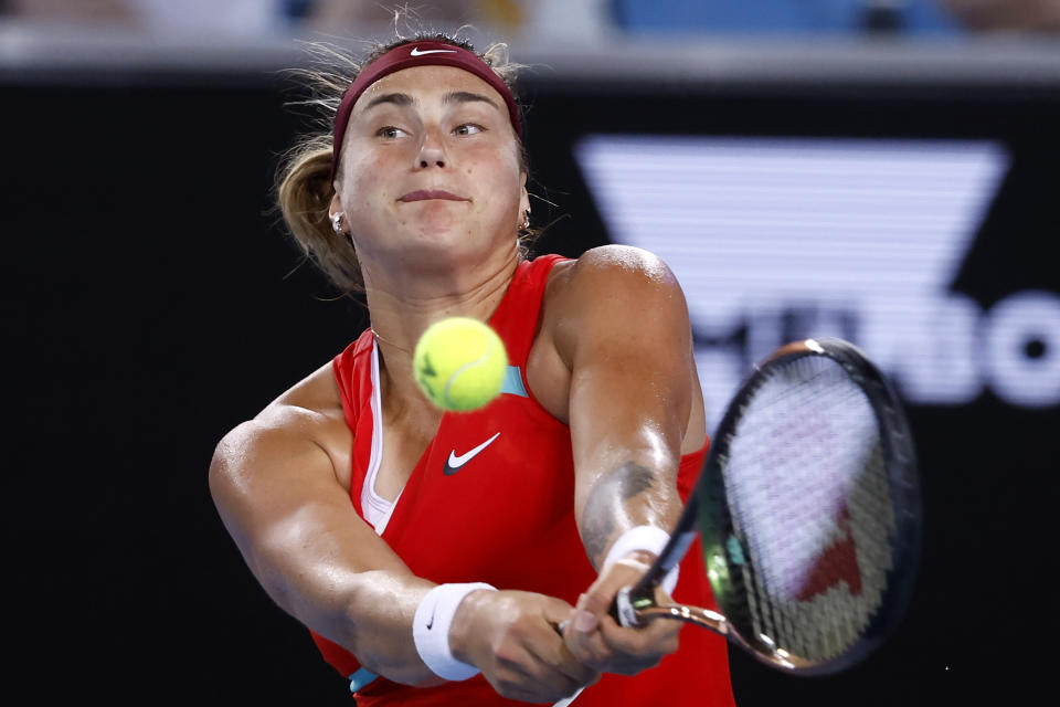 Aryna Sabalenka of Belarus makes a backhand return to Kaia Kanepi of Estonia during their fourth round match at the Australian Open tennis championships in Melbourne, Australia, Monday, Jan. 24, 2022. (AP Photo/Hamish Blair)