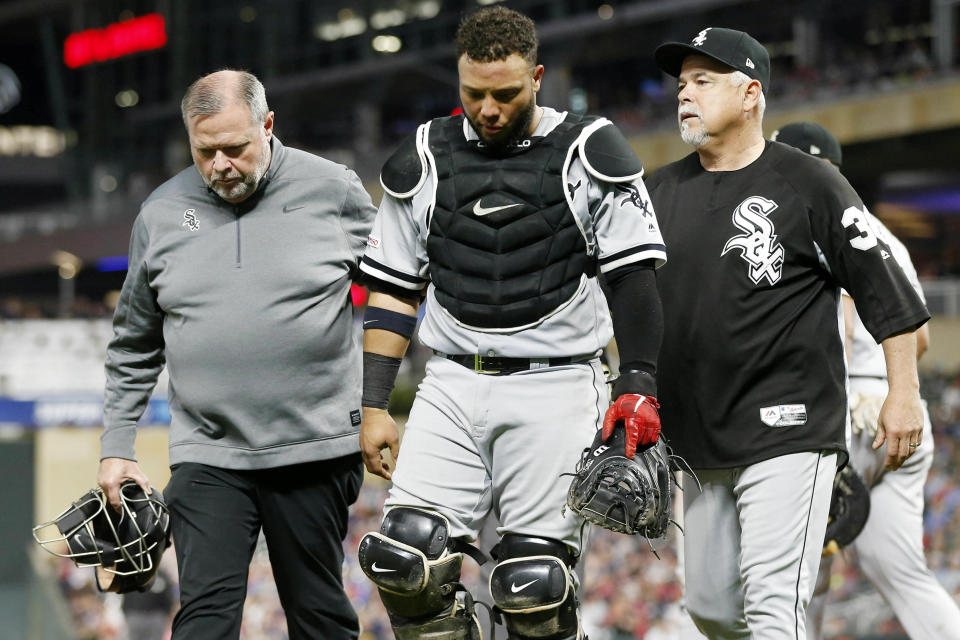 FILE - Chicago White Sox catcher Welington Castillo, center, is helped off the field by manager Rick Renteria, right, and trainer Brian Ball, who holds Castillo's broken face mask, during the eighth inning of the team's baseball game against the Minnesota Twins on May 24, 2019, in Minneapolis. Ball, the former athletic trainer for the White Sox, is alleging in a lawsuit that he was fired by the team because of his sexual orientation, age and disability. In a team statement, the White Sox described Ball's allegations as “baseless” and promised to vigorously defend the organization's reputation. (AP Photo/Jim Mone, File)