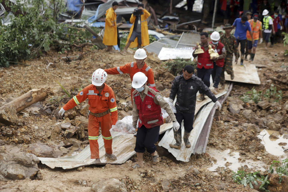 Members of a Myanmar rescue team carry a body at a landslide-hit area in Paung township, Mon State, Myanmar Saturday, Aug. 10, 2019. A landslide has buried more than a dozen village houses in southeastern Myanmar. (AP Photo)