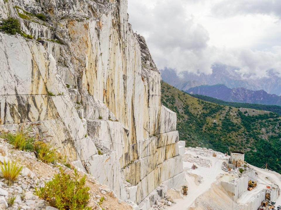 A wide view of a marble mountain range dotted with quarries