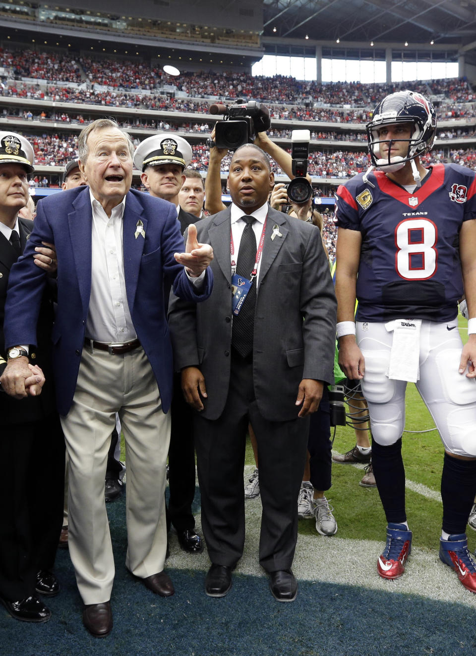 Former President George H.W. Bush tosses the coin as Houston Texans quarterback Matt Schaub (8) looks on before an NFL football game against the Buffalo Bills, Sunday, Nov. 4, 2012, in Houston. (AP Photo/Eric Gay)