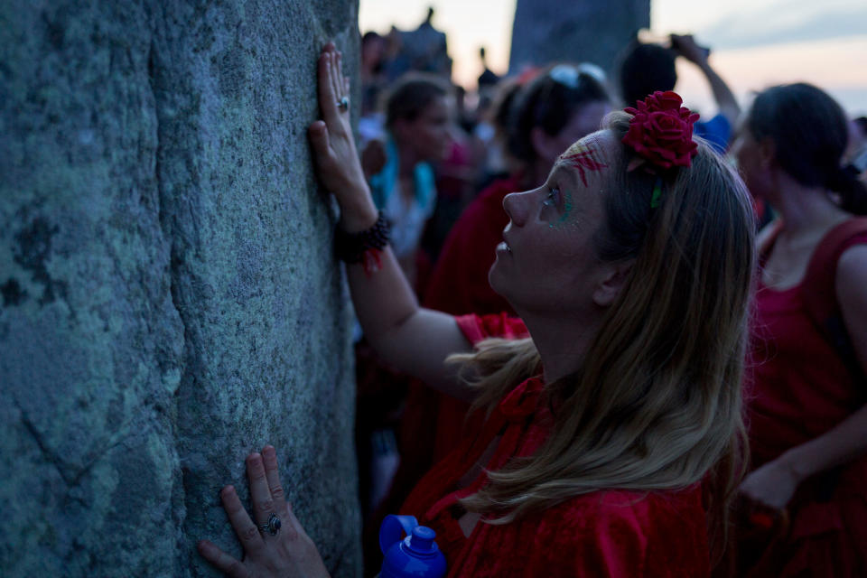 A reveller touches one of the ancient stones