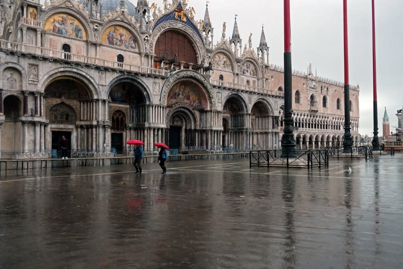 Tourists walk in St. Mark’s Square after days of severe flooding in Venice