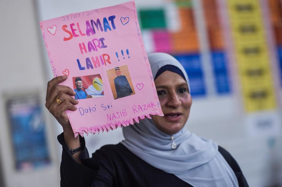 A supporter holds up a birthday card for Datuk Seri Najib Razak at the lobby of the Kuala Lumpur Court Complex July 23, 2019. — Picture by Mukhriz Hazim