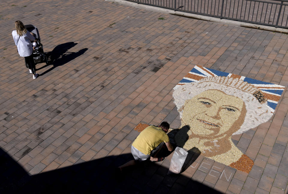 Artist Alken Pozhega makes a giant portrait of Britain's Queen Elizabeth II, made entirely of grain of corn, peas and beans in the town of Gjakova, Kosovo, Sept. 10, 2022. (AP Photo/Sylejman Kllokoqi)