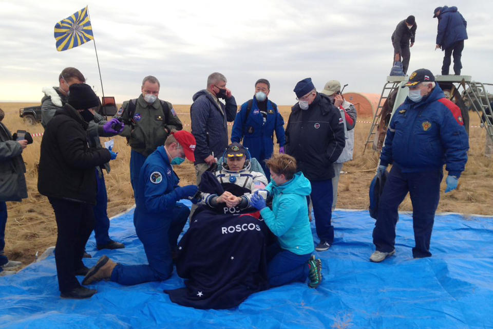 In this photo released by Roscosmos Space Agency, NASA astronaut Chris Cassidy sits in a chair shortly after landing near town of Dzhezkazgan, Kazakhstan, Thursday, Oct. 22, 2020. The Soyuz MS-16 capsule carrying Cassidy and Roscosmos' Anatoly Ivanishin and Ivan Vagner landed on the steppes of Kazakhstan southeast of the town of Dzhezkazgan on Thursday. After a brief medical checkup, the three will be taken by helicopters to Dzhezkazgan from where they will depart home. (Roscosmos Space Agency, via AP)