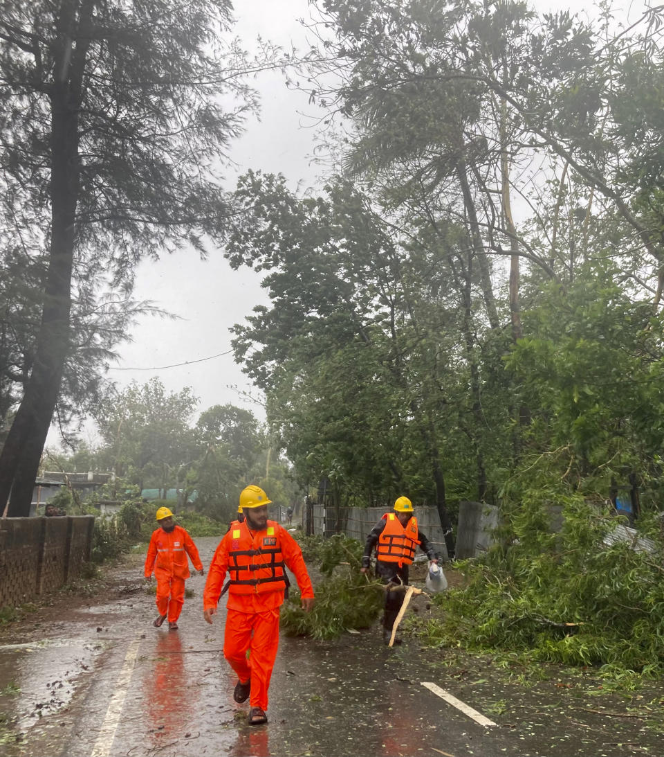 Rescue workers remove the fallen tress after a storm in Teknaf, near Cox's Bazar, Bangladesh, Sunday, May 14, 2023. Bangladesh and Myanmar braced Sunday as a severe cyclone started to hit coastal areas and authorities urged thousands of people in both countries to seek shelter. (AP Photo/Al-emrun Garjon)