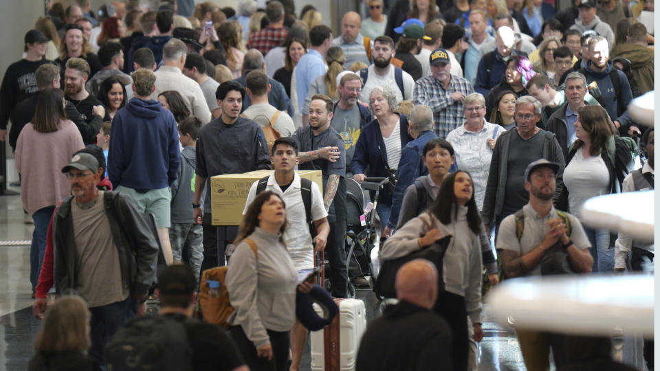 Travelers walk through Salt Lake City International Airport Friday, May 24, 2024, in Salt Lake City. A record number of Americans are expected to travel over the 2024 Memorial Day holiday. (AP Photo/Rick Bowmer)