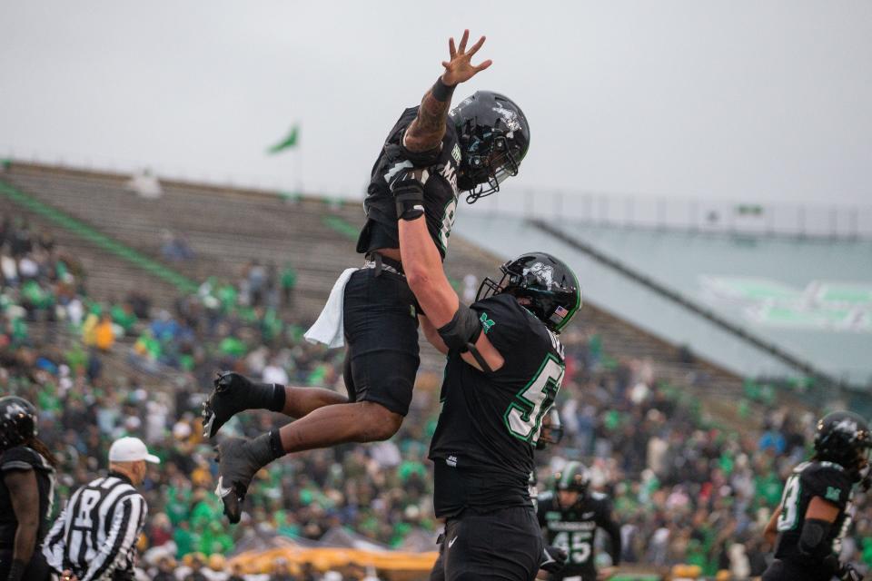 Marshall's Ethan Driskell (52) lifts running back Khalan Laborn (8) as they celebrate a touchdown against Appalachian State on Nov. 12, 2022, in Huntington, West Virginia.