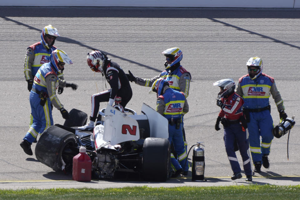 Josef Newgardenk, third from left, climbs out of his car after hitting a wall during an IndyCar Series auto race, Sunday, July 24, 2022, at Iowa Speedway in Newton, Iowa. (AP Photo/Charlie Neibergall)