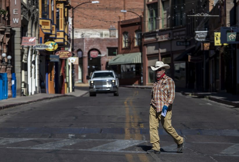 BISBEE, AZ - MAY 26: A man in a hat walks across Main Street Tuesday, May 26, 2020 in Bisbee, AZ. (Brian van der Brug / Los Angeles Times)