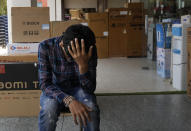 Sahil Rajput, 21, sits outside an electronic shop where he works in Rohtak, India, July 18, 2022. Rajput has been fervently preparing for a job in the army, working in a low-paid data-entry job to afford private coaching to become a soldier and support his unemployed parents. But in June, the government overhauled military recruitment to cut costs and modernize, changing long-term postings into four-year contracts after which only 25% of recruits will be retained. Rajput knows he might not be able to get a permanent army job. "But I have no other options," he said. (AP Photo/Manish Swarup)