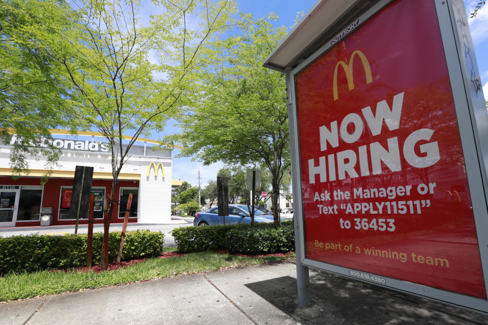 In this Monday, July 1, 2019 photo, a help wanted sign appears on a bus stop in front of a McDonald's restaurant in Miami. On Tuesday, July 9, the Labor Department reports on job openings and labor turnover for April. (AP Photo/Wilfredo Lee)