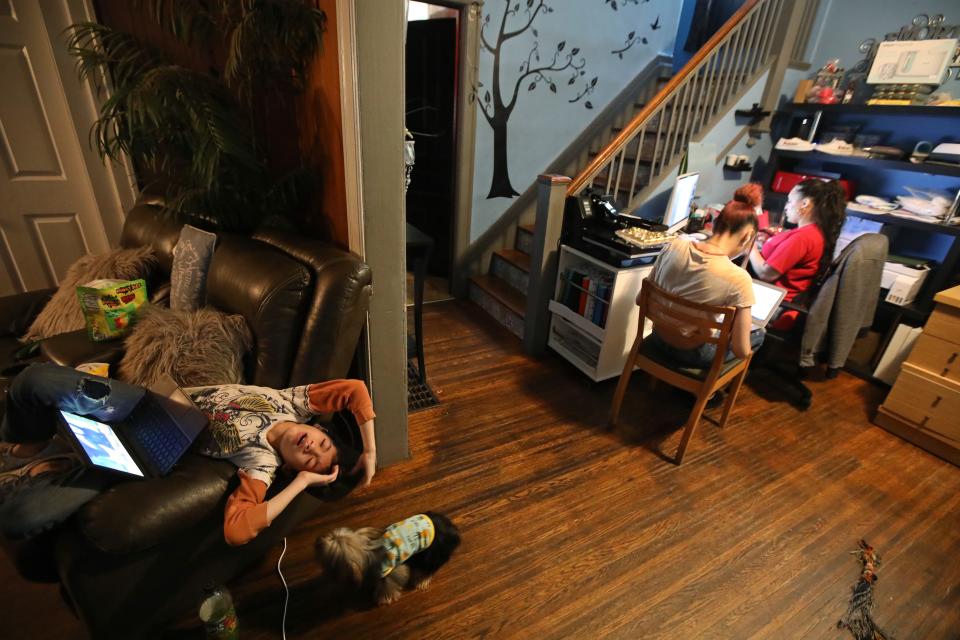 A worn out Jacob Sepulveda , a fifth grader, reacts to more questions in his Zoom classroom as he works in the living room while mother Zumarie Sepulveda works on a Zoom training session and sister Reina, a senior at East High, waits for her class to start, as they work in the dining room of their home in Rochester Tuesday May 25, 2021. The entire Sepulveda family has spent the school year learning remotely due to COVID-19. 