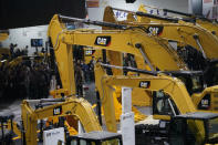 FILE PHOTO: People visit heavy machinery of Caterpillar at Bauma China, the International Trade Fair for Construction Machinery in Shanghai, China November 27, 2018. REUTERS/Aly Song