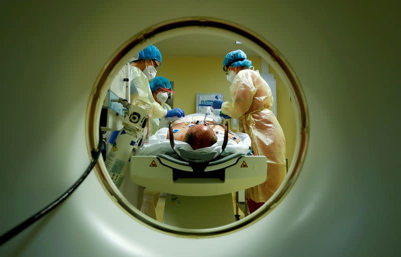 FILE PHOTO: Members of the medical staff in protective suits treat a patient suffering from the coronavirus disease (COVID-19) with a computer tomograph in the Intensive Care Unit (ICU) at Havelhoehe community hospital in Berlin