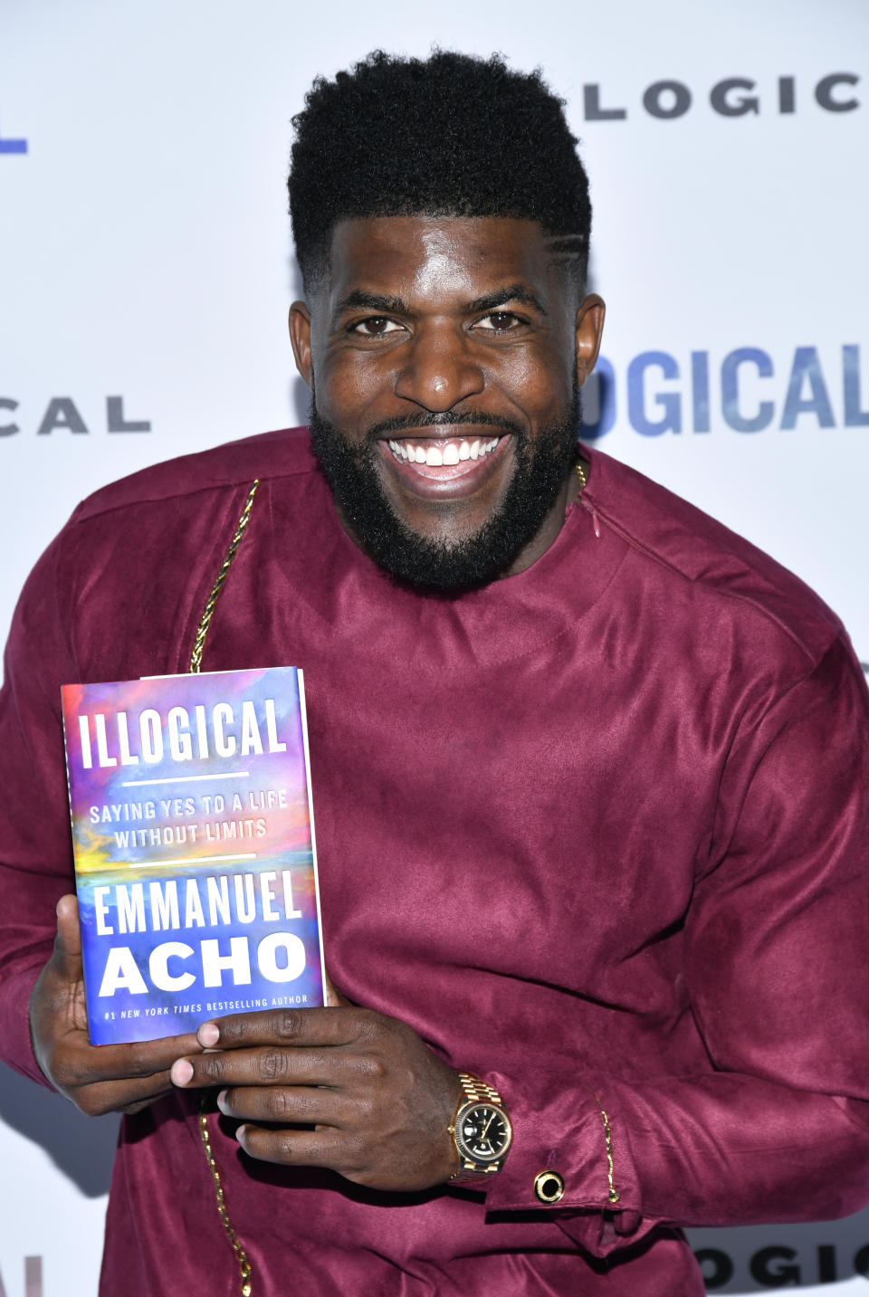 Emmanuel Acho Holding A Copy Of His Book 'Illogical'