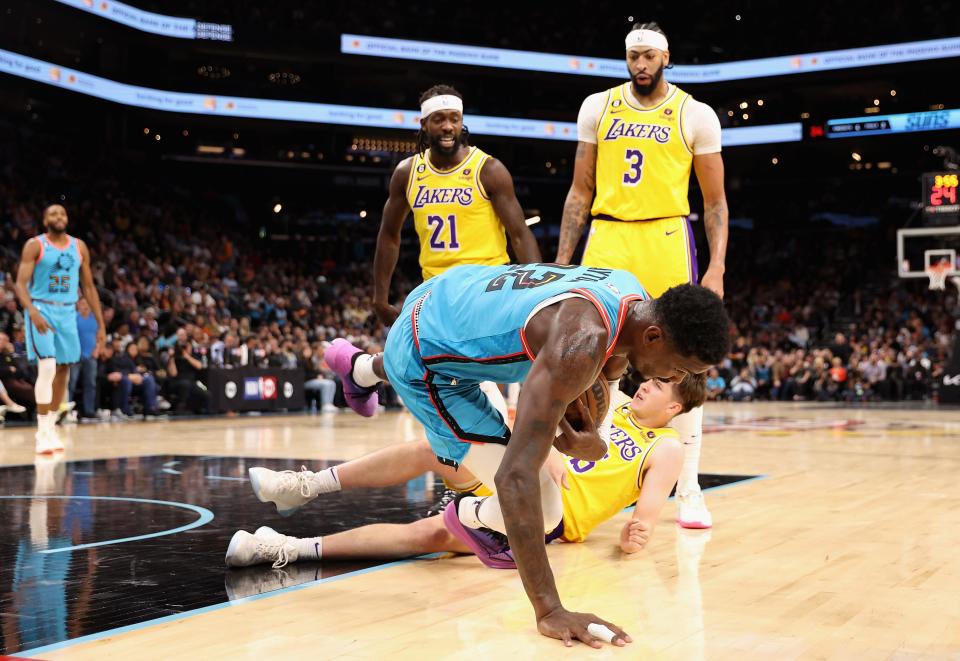 Deandre Ayton #22 of the Phoenix Suns falls over Austin Reaves #15 of the Los Angles Lakers after being pushed by Patrick Beverley #21during the second half of the NBA game at Footprint Center on Nov. 22, 2022, in Phoenix, Arizona. Beverley was ejected from the play. The Suns defeated the Lakers 115-105.