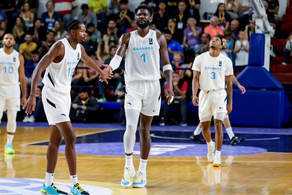 Deandre Ayton gives five to Kentwan Smith during Bahamas win Sunday over Argentina.
