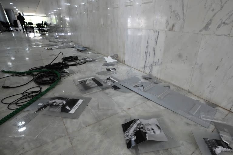 Fotografías de expresidentes brasileños yacen desperdigadas en el piso del vestíbulo del Palacio de Planalto, la oficina del presidente, al día siguiente de que fuera allanada por simpatizantes del exmandatario Jair Bolsonaro, el lunes 9 de enero de 2023, en Brasilia, Brasil. Los inconformes también invadieron el Congreso y el Supremo Tribunal Federal. (AP Foto/Eraldo Peres)