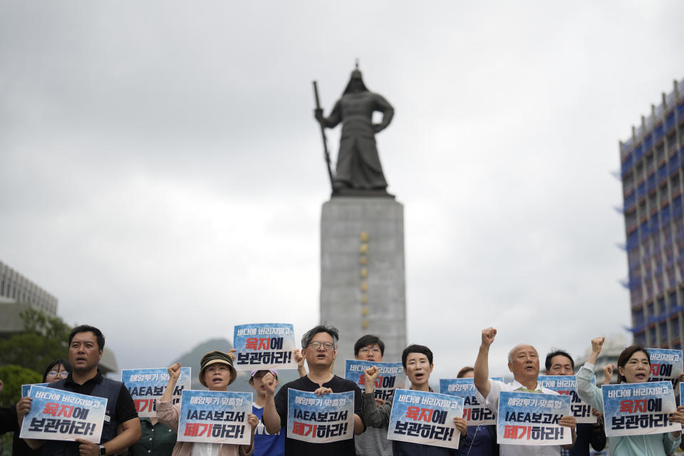 Members of civic groups shout slogans during a rally to oppose Japanese government's decision to release treated radioactive water into the sea from the Fukushima nuclear power plant, in Seoul, South Korea, Wednesday, July 5, 2023. The letters read "Abolish a report of the IAEA." (AP Photo/Lee Jin-man)