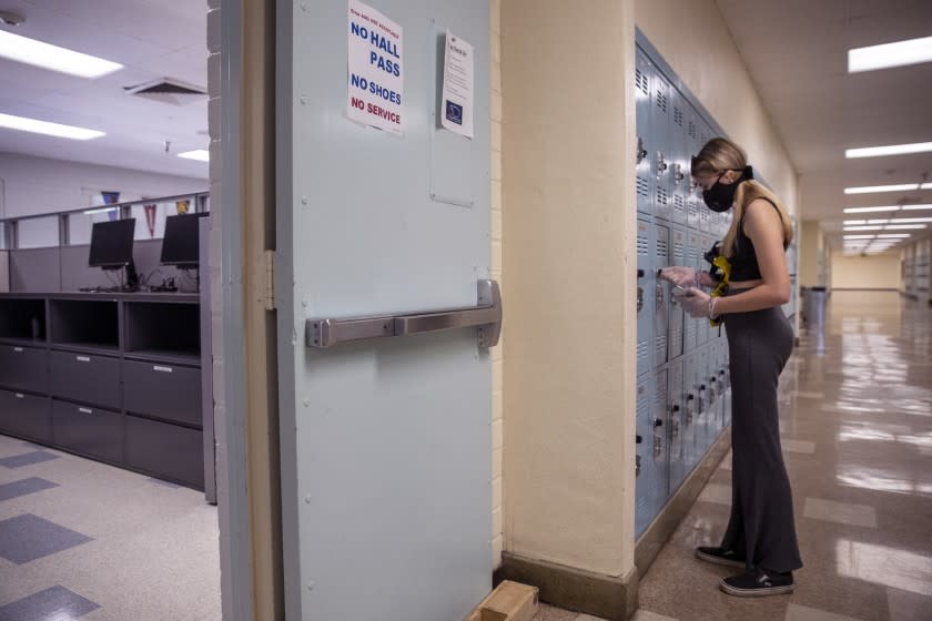 WOODLAND HILLS, CA - APRIL 30: Sophomore Kerry Miller opens up her locker to gather books and belongings at El Camino Real Charter High School on Thursday, April 30, 2020 in Woodland Hills, CA. School officials were allowing no more than 5 students at a time on campus to take home their belongings. (Brian van der Brug / Los Angeles Times)