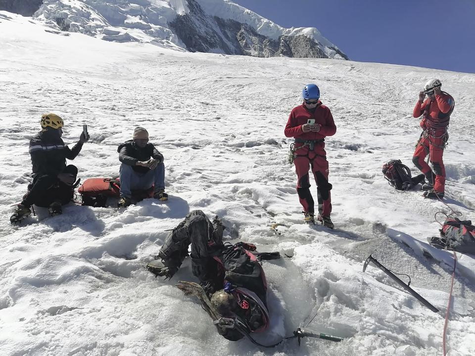 This photo distributed by the Peruvian National Police shows officers surrounding the body of who they identify as U.S. mountain climber William Stampfl, on Huascaran mountain in Huaraz, Peru, July 5, 2024. Peruvian authorities announced on Tuesday, July 9, 2024, that they have found the mummified body of the American man who died 22 years ago, along with two other American climbers, after the three were trapped in an avalanche while trying to climb Peru's highest mountain. (Peruvian National Police via AP)