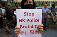 A woman holds a placard during a demonstration outside the Queen Elizabeth Stadium in Hong Kong, Thursday, Sept. 26, 2019. Riot police on Thursday begun securing a stadium in downtown Hong Kong ahead of a town hall session by embattled city leader Carrie Lam, aimed at cooling down months of protests for greater democracy in the semi-autonomous Chinese territory. (AP Photo/Vincent Thian)