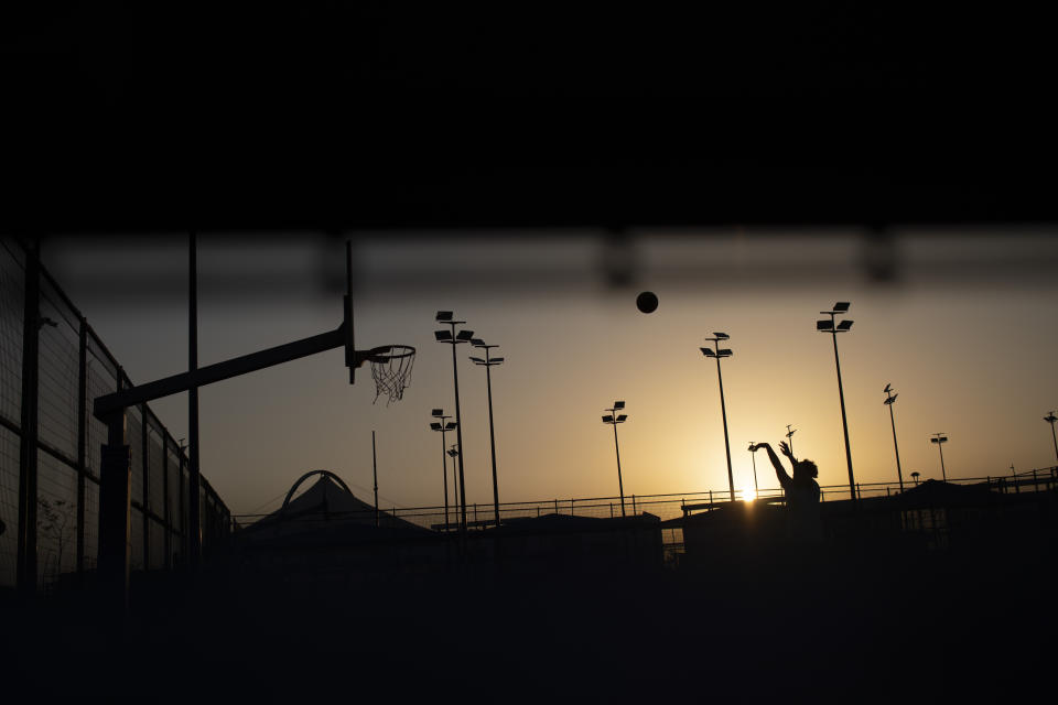 A teenager shoots the ball in an outdoor basketball court in Sderot, Israel, Tuesday , July 20, 2021. No place in Israel has been hit harder by Palestinian rocket fire than Sderot, a working-class town just about a mile (1.5 kilometers) from the Gaza border. Although Sderot is enjoying an economic boom and revival, a generation of children and parents are suffering from the traumatic effects of two decades of rocket fire that experts are still struggling to understand. (AP Photo/Ariel Schalit)