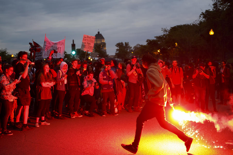 <p>A protester runs with a flare outside the National Assembly of Quebec during a demonstration ahead of the Group of Seven (G7) Leaders’ Summit in Quebec City, Quebec, Canada on June 7, 2018. (Photo: Cole Burston/Bloomberg via Getty Images </p>