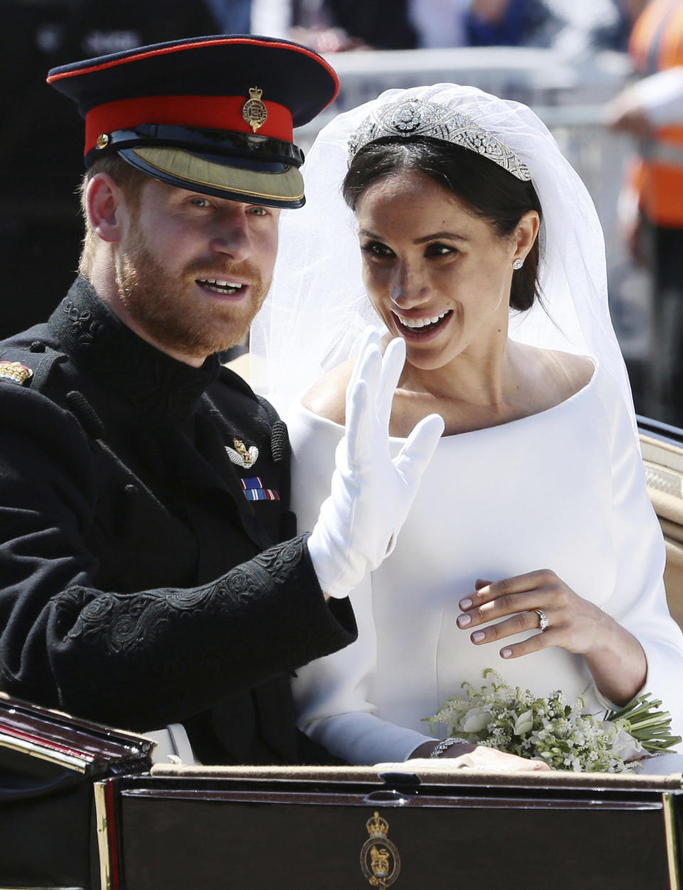 FILE - In this Saturday, May 19, 2018 file photo, Britain's Prince Harry and Meghan Markle ride in an open-topped carriage after their wedding ceremony at St. George's Chapel in Windsor Castle in Windsor, near London, England. Princess Diana’s little boy, the devil-may-care red-haired prince with the charming smile is about to become a father. The arrival of the first child for Prince Harry and his wife Meghan will complete the transformation of Harry from troubled teen to family man, from source of concern to source of national pride. (Aaron Chown/pool photo via AP, File)