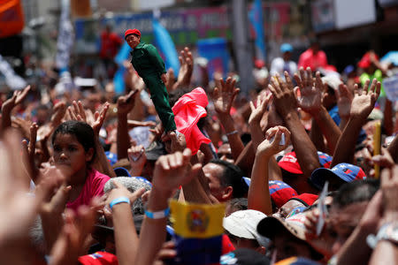 Supporters of Venezuela's President Nicolas Maduro holding a doll depicting Venezuela's late President Hugo Chavez, attend a campaign rally Charallave, Venezuela May 15, 2018. REUTERS/Carlos Garcia Rawlins