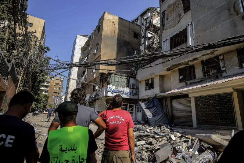 Civil defence workers inspect destruction in buildings that were targeted by an Israeli drone in Beirut's southern suburb. 4 people were killed and wounding more than 70 people. The Israeli military said Tuesday it has carried out a "targeted attack" on a commander of the pro-Iranian Hezbollah militia in Beirut.  The explosion occurred three days after a deadly rocket attack on the Israeli-occupied Golan Heights. Marwan Naamani/dpa