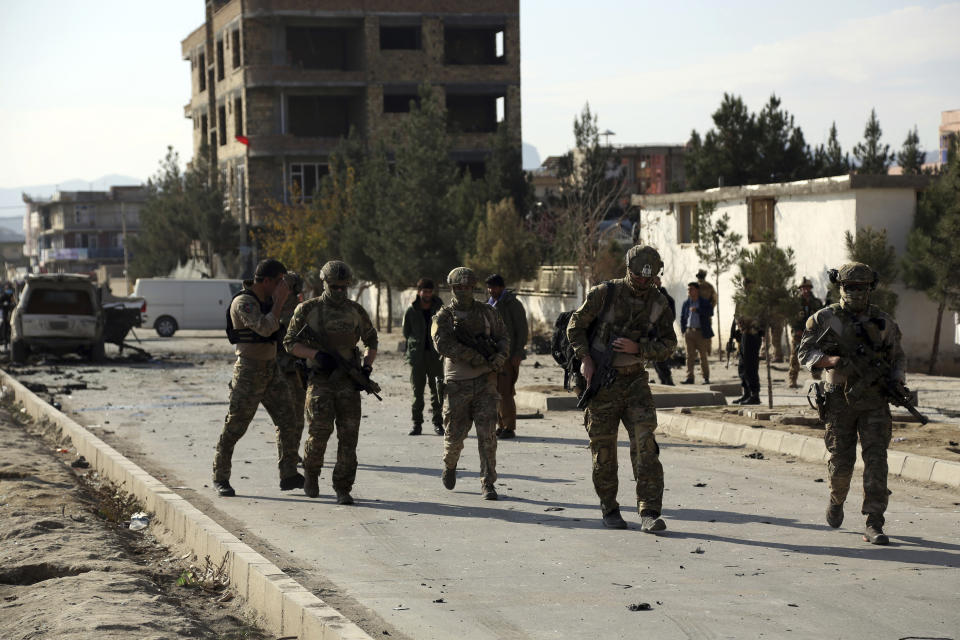 Foreign and local security personnel gather at the site of car bomb attack in Kabul, Afghanistan, Wednesday, Nov. 13, 2019. A car bomb detonated in the Afghan capital during Wednesday's morning commute, killing seven people and wounding at least seven, officials said. (AP Photo/Rahmat Gul)