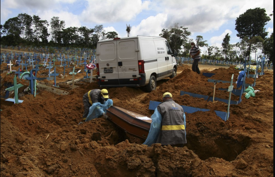 Two men lower a casket into a grave.