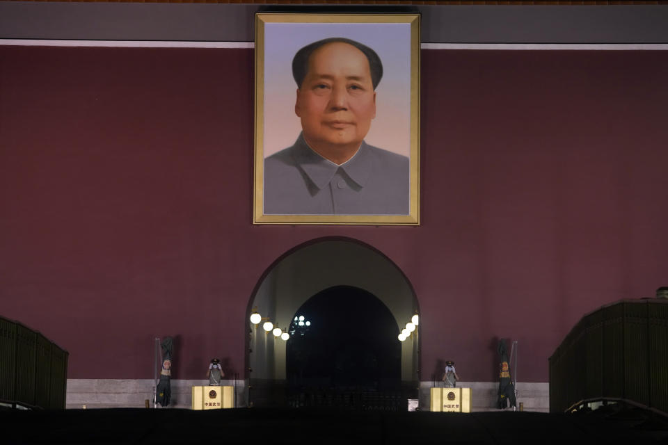 Chinese paramilitary policemen put on sunglasses while on duty, as spot lights light up Tiananmen Gate with its iconic portrait of late Chinese leader Mao Zedong in Beijing on Thursday, July 15, 2021. (AP Photo/Ng Han Guan)