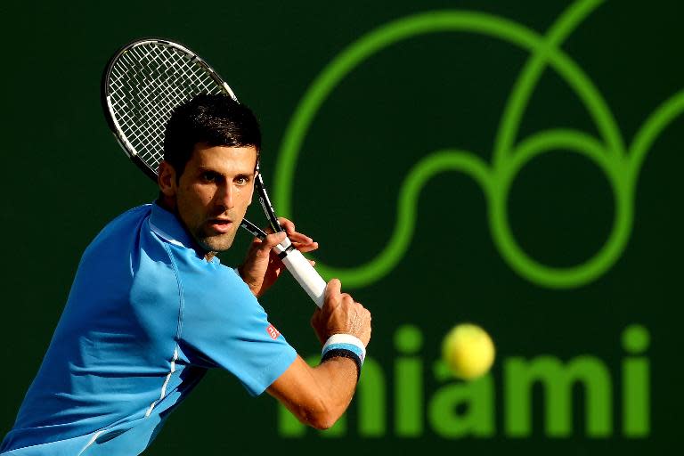 Novak Djokovic returns a shot during his Miami Open match against Steve Darcis on March 30, 2015 in Key Biscayne